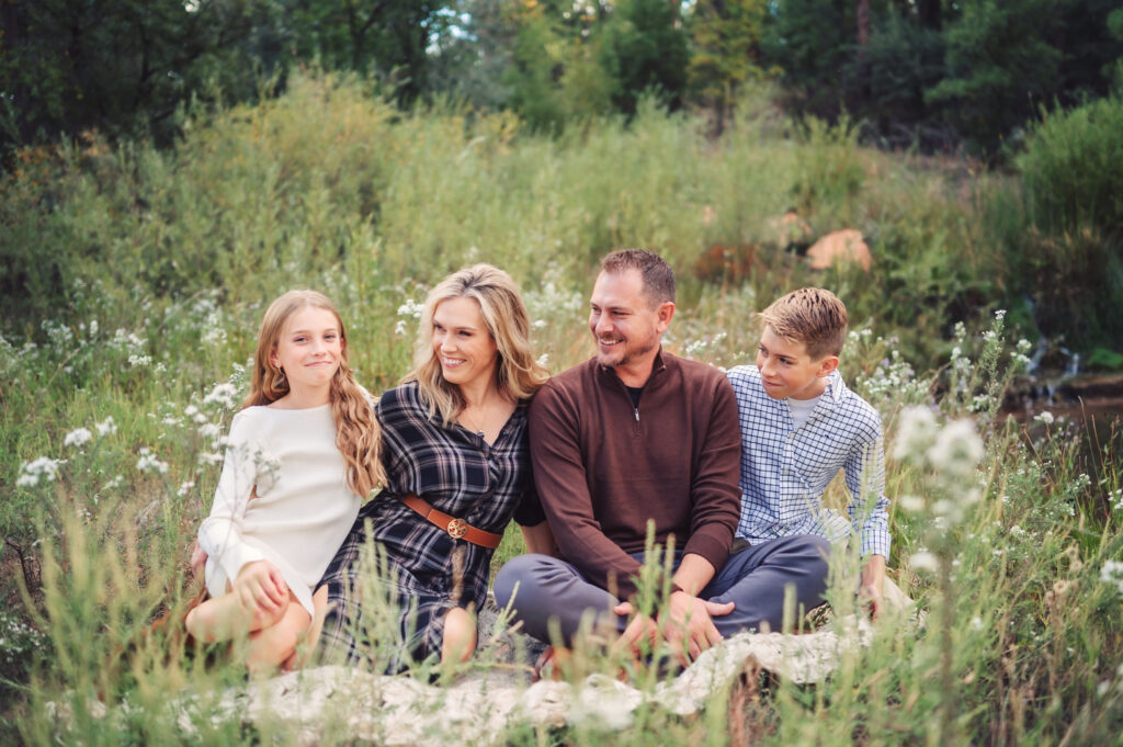 a group of people sitting in a field, having their photo taken by Katelyn McKenzie Photography