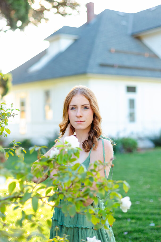 a high school senior posing in front of a house.
